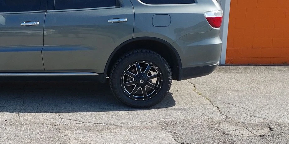 Close-up of a black aftermarket wheel on the gray SUV outside Belt Alignment